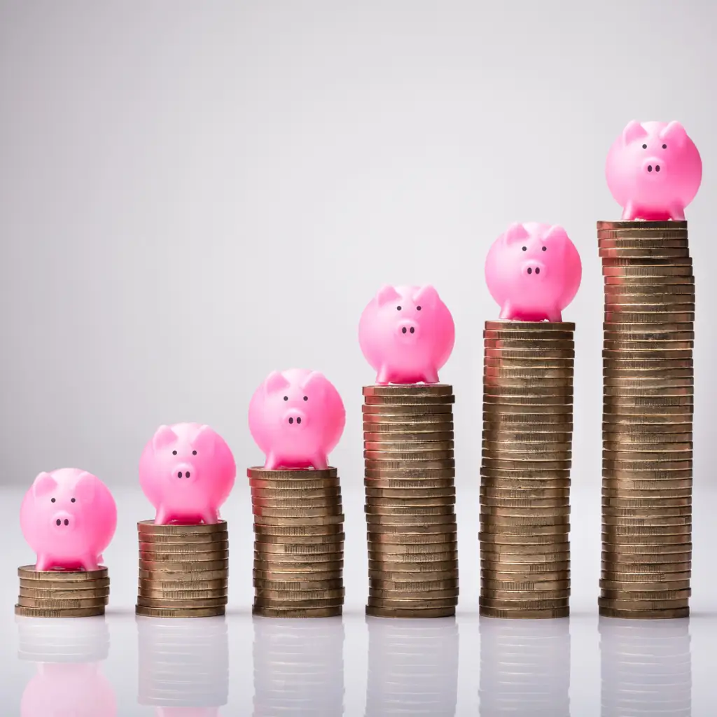 Piggy banks on stacked coins, increasing height
