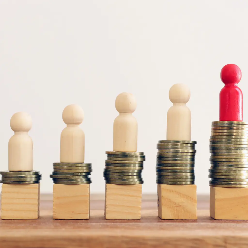Toy Pawn Pieces Coins Stacked coins with figures on top, inequality concept.