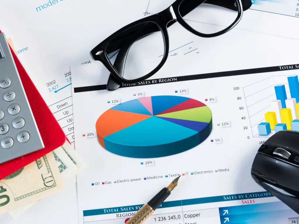Paper Chart Graphs Financial reports with charts and calculator on desk.