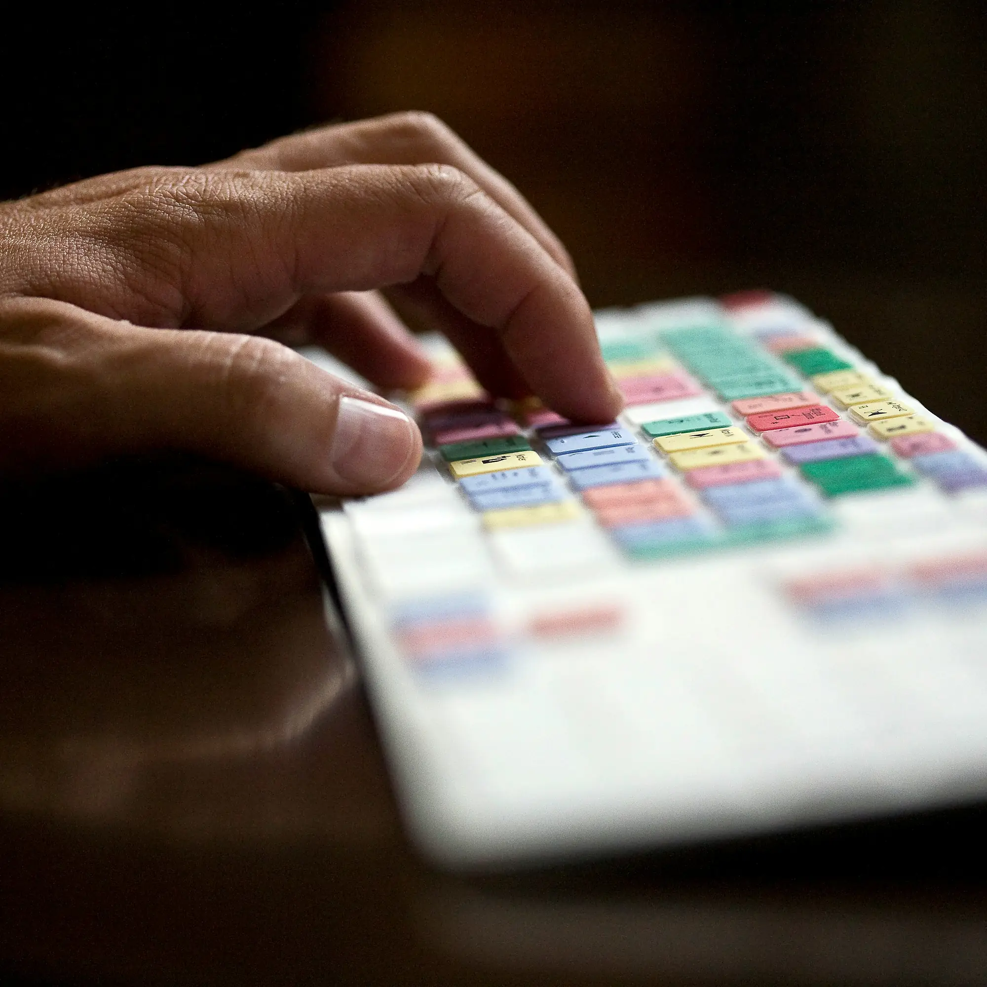 Hand typing on colorful editing keyboard.